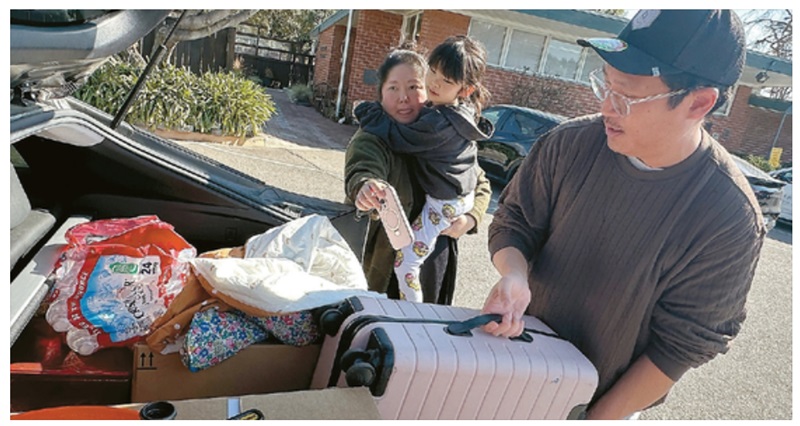 Ray An (R) loads her luggage into the trunk of her car to leave the hotel where she was temporarily staying on January. 17. By SANGJIN KIM