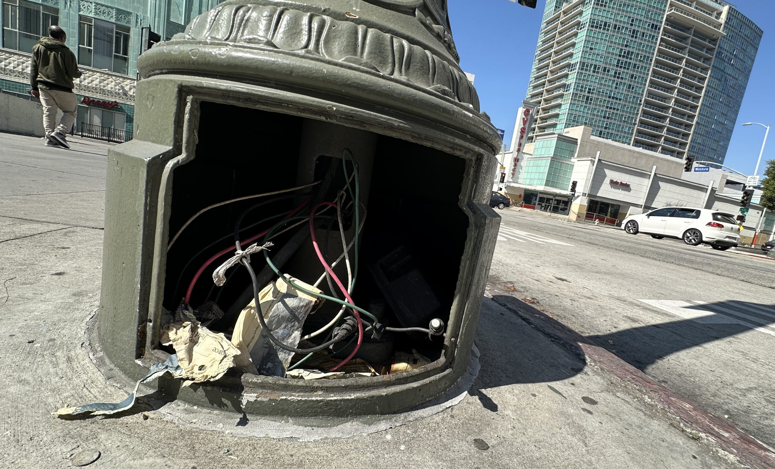 Exposed base of a streetlight missing its protective panel in LA Koreatown due to copper wire theft.