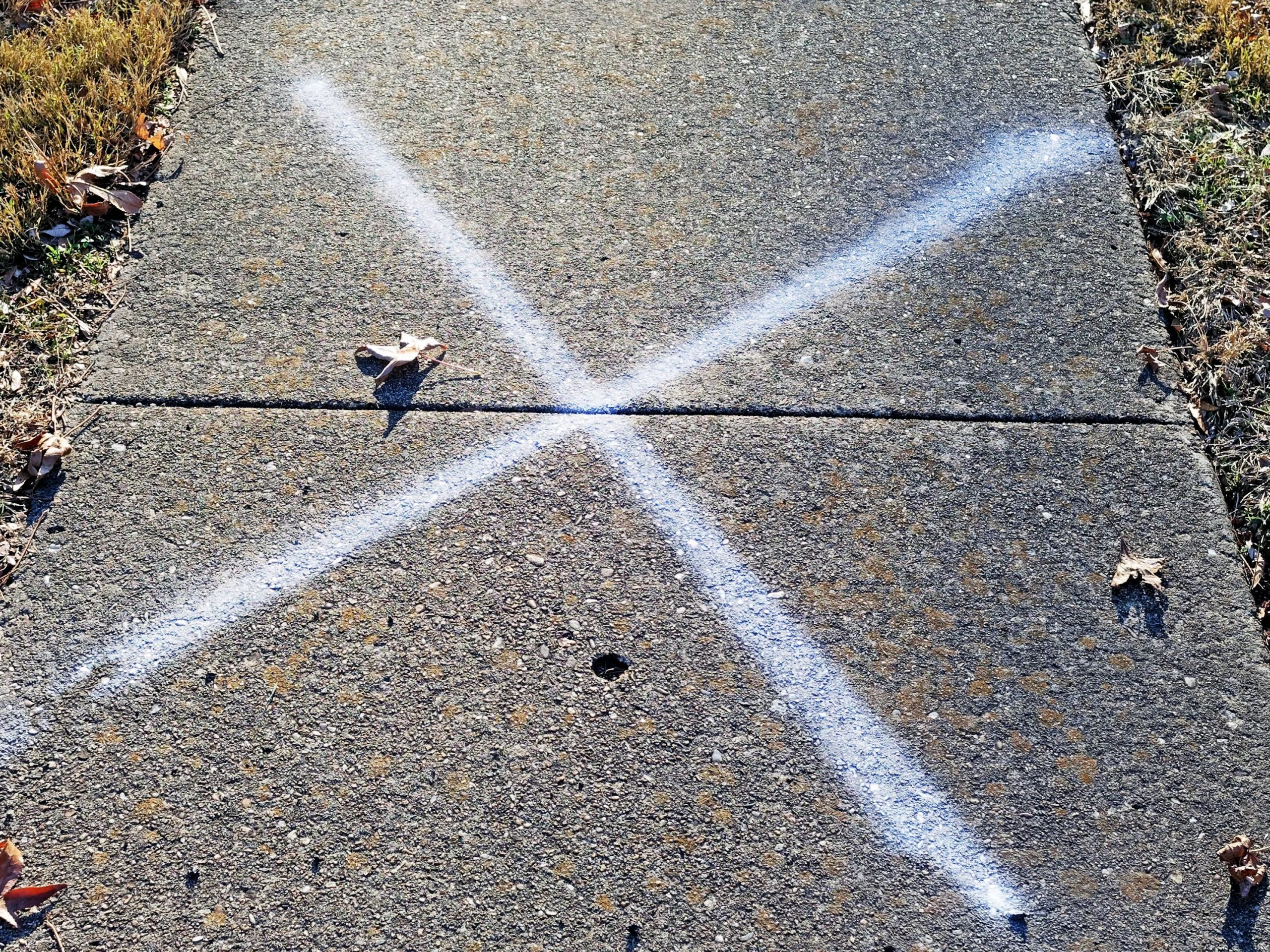 Burglary target marking chalk X on sidewalk