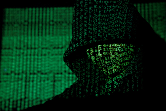 A projection of cyber code on a hooded man is pictured in this illustration picture taken on May 13, 2017. [REUTERS]