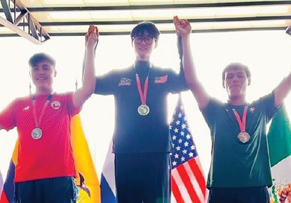 Nathan Lim on podium after winning junior shooting gold