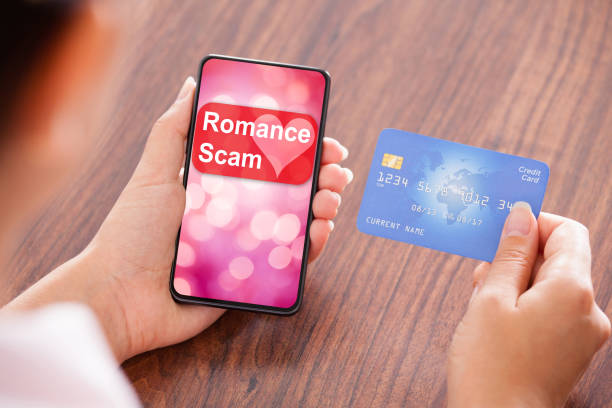 phone screen shows romance scam as hand holds credit card, illustrating Korean romance scam