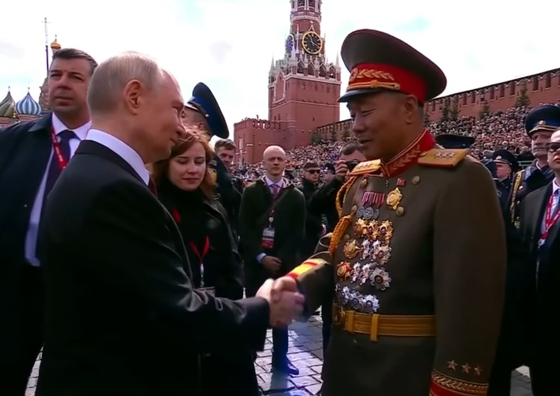Russian President Vladimir Putin, left, and Kim Yong-bok, deputy chief of the General Staff of the Korean People's Army, shake hands during Russia's Victory Day celebration on May 9. [SCREEN CAPTURE]