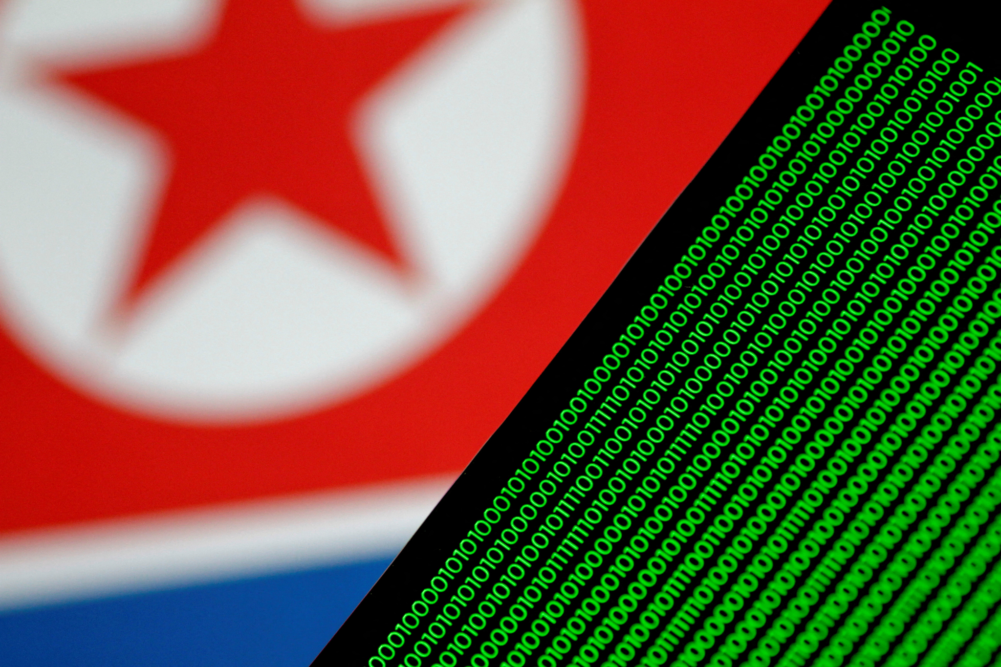 Binary code is seen on a screen against a North Korean flag in this illustration from Nov. 1, 2017. [REUTERS]