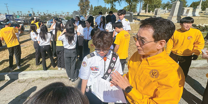 Yoonsook Park inspects Rosedale Cemetery with Korean American youth during history project site check