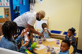 Teacher helping young child at a daycare center, highlighting Washington childcare costs exceeding rent