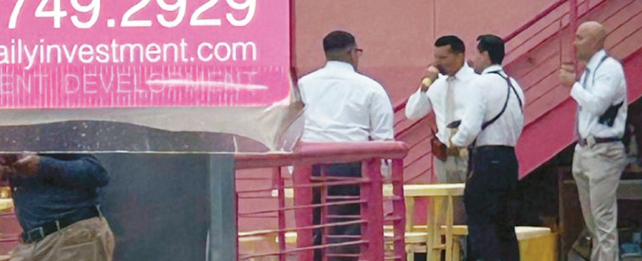 ICE and FBI agents speak outside a second-floor shop at San Pedro Fashion Mart in LA’s Korean American garment district