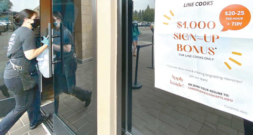 Restaurant hiring flyer posted at entrance, referencing federal tip tax exemption bill