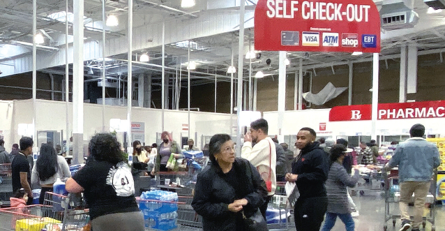Costco checkout zone with customers using staffed registers related to costco scan and go article