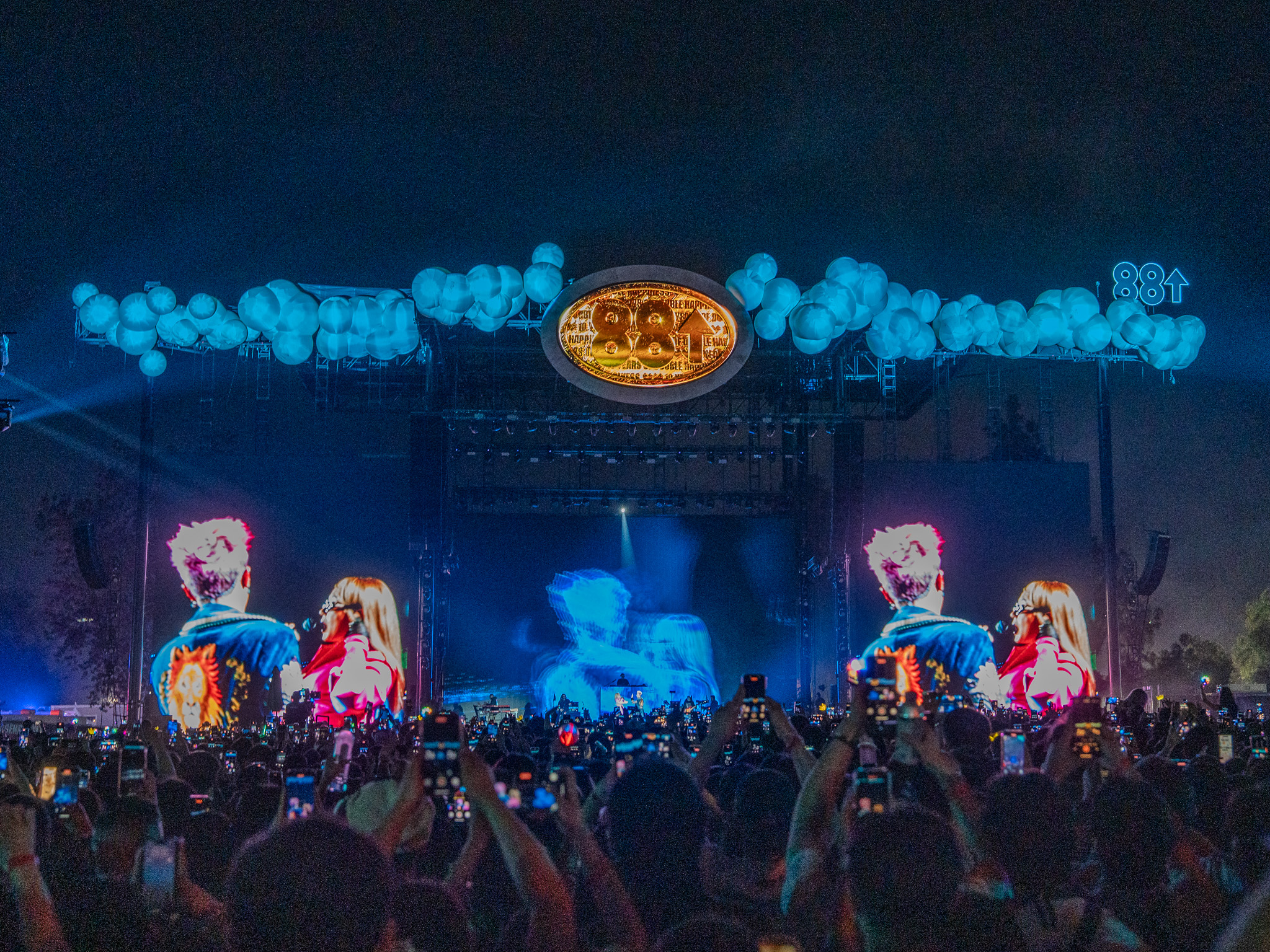 G-Dragon and CL on stage at Head in the Clouds 2025 as crowd films the moment