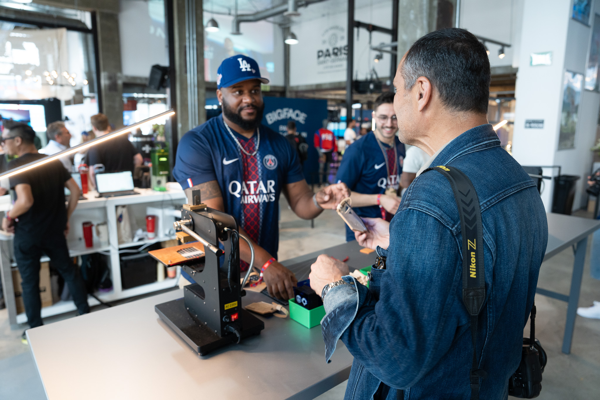 Visitor requesting personalized leather tag at customization booth inside PSG House LA