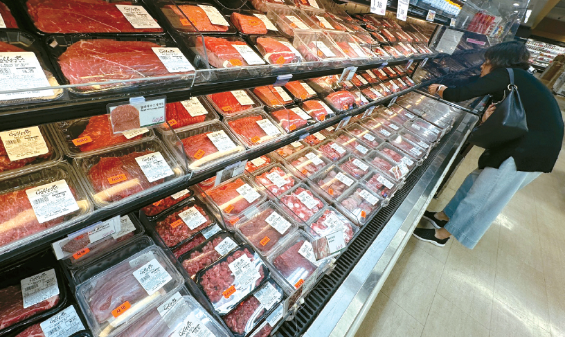 Korean shopper selects beef at a Korean market in LA Koreatown in rising beef prices