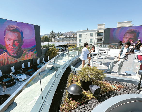 Tesla Diner Hollywood rooftop movie terrace with Optimus robot and seating