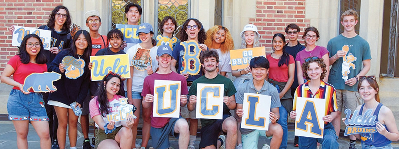 UCLA freshmen pose with school banner after completing orientation on campus