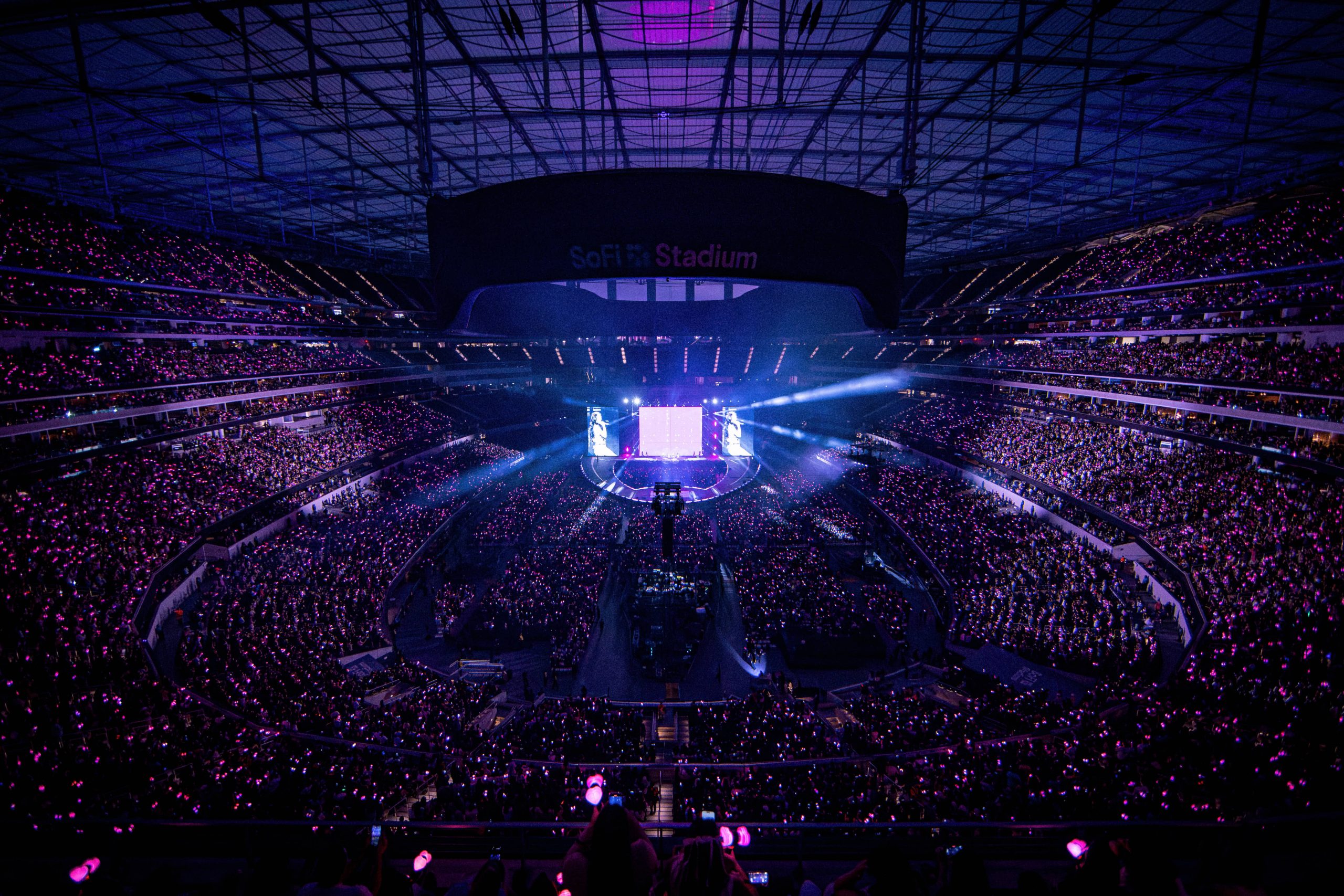 Packed stadium with BLACKPINK lightsticks glowing throughout the crowd during concert