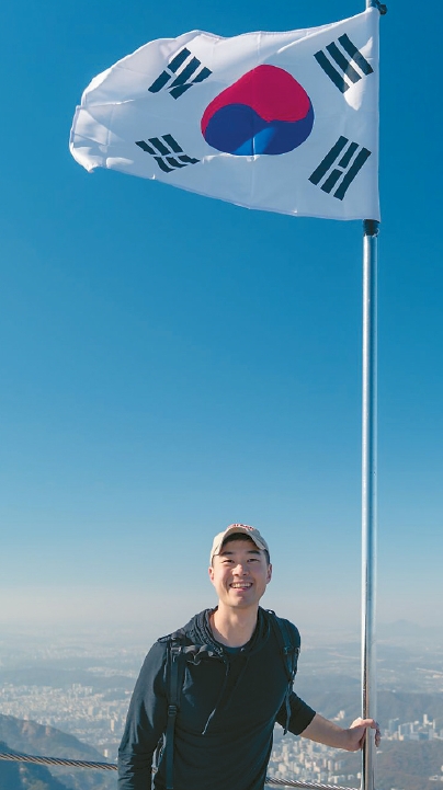 Tiger Cho, a Korean American entrepreneur, stands at the summit of Samgaksan in Seoul after launching his community network K-Bridge.