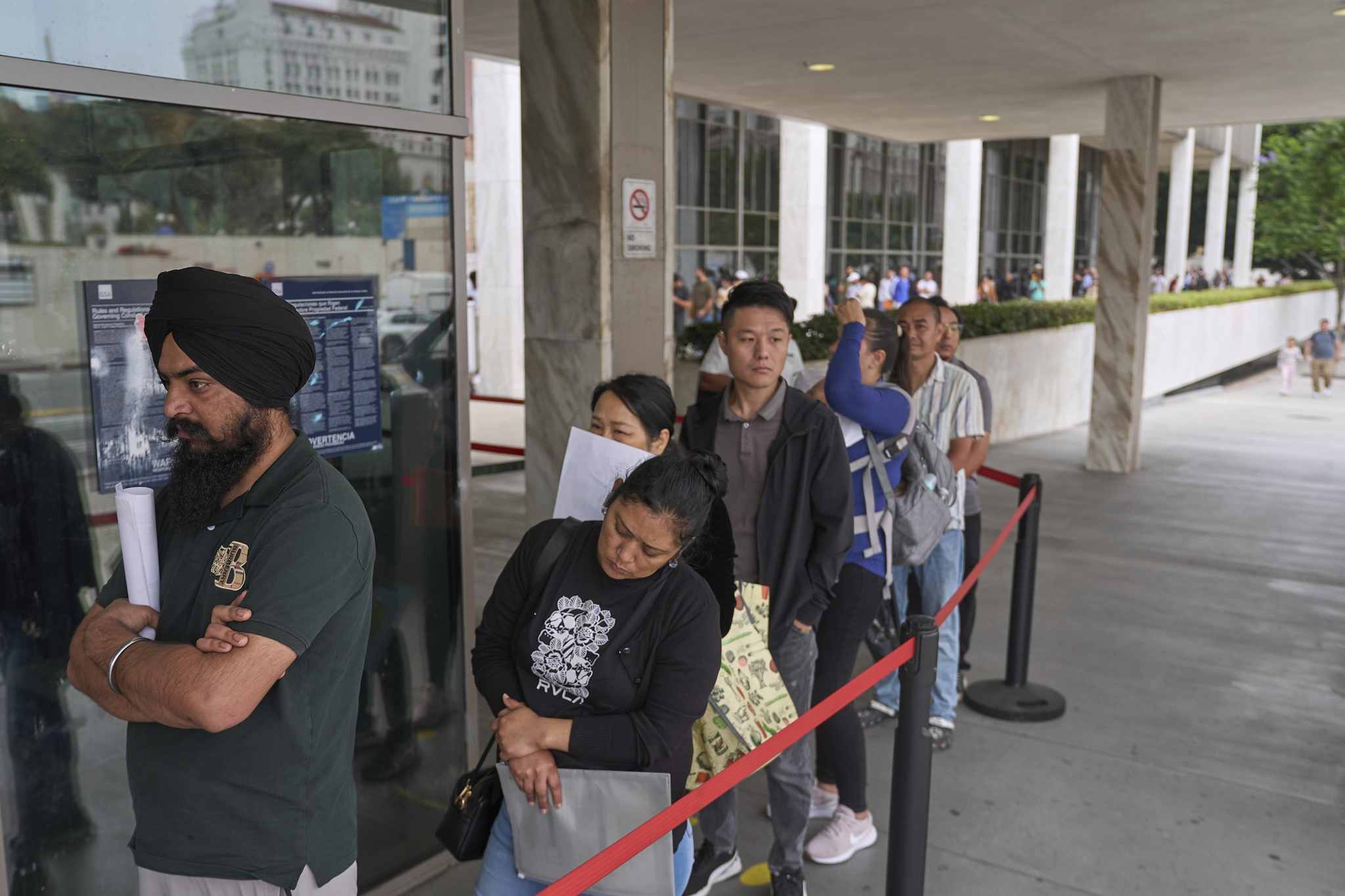 People waiting in line outside the Los Angeles Federal Building, home to USCIS, during the USCIS anti-Americanism visa review policy rollout in June 2025.