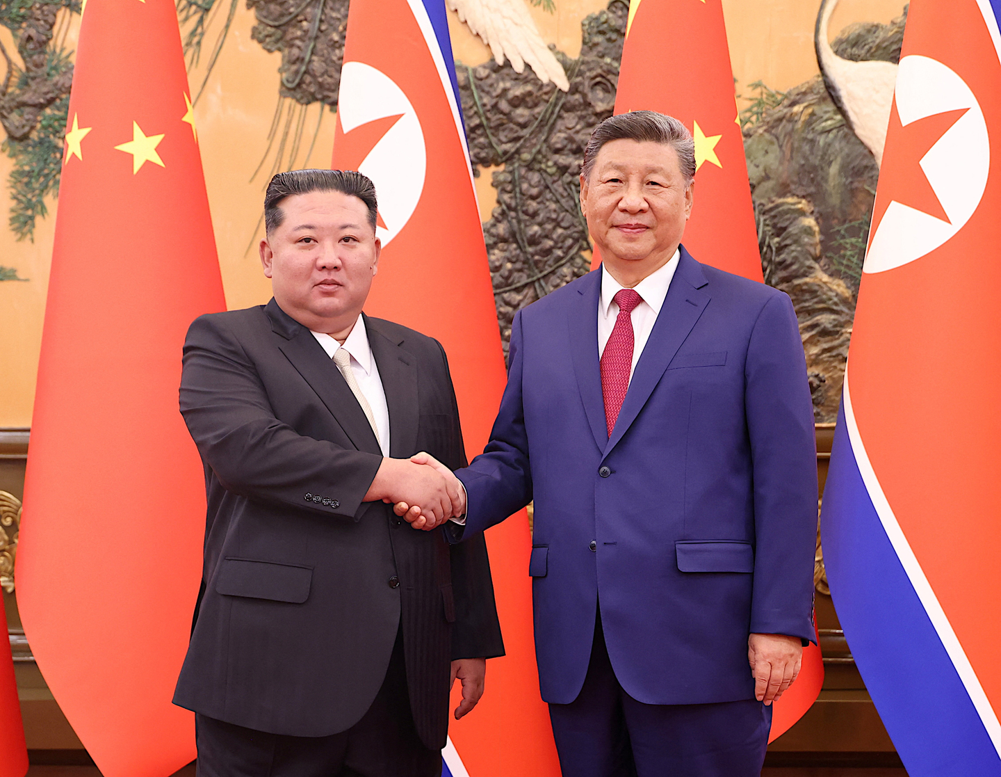 North Korean leader Kim Jong-un, left, and Chinese President Xi Jinping shake hands at the Great Hall of the People in Beijing on Sept. 4. [REUTERS]
