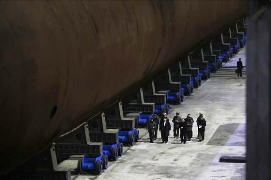 North Korean leader Kim Jong-un inspects what appears to be a nuclear-powered strategic missile submarine under construction at a facility in North Korea on March 8. [RODONG SINMUN]
