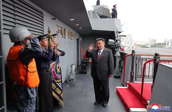 This photo, carried by North Korea's official Korean Central News Agency on Oct. 6, shows North Korean leader Kim Jong-un, right, visiting the 5,000-ton destroyer, named the Choe Hyon, on Oct. 5. [KCNA]