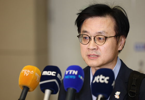 Industry Minister Kim Jung-kwan answers questions from reporters after arriving at the Incheon International Airport on Oct. 20. [YONHAP]