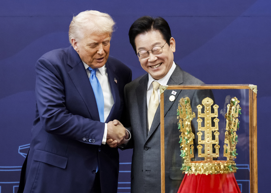 President Lee Jae Myung, right, shakes hands with U.S. President Donald Trump after gifting him a replica of a Silla-era gold crown at the Gyeongju National Museum in North Gyeongsang ahead of their bilateral summit on Oct. 29. [JOINT PRESS CORPS]