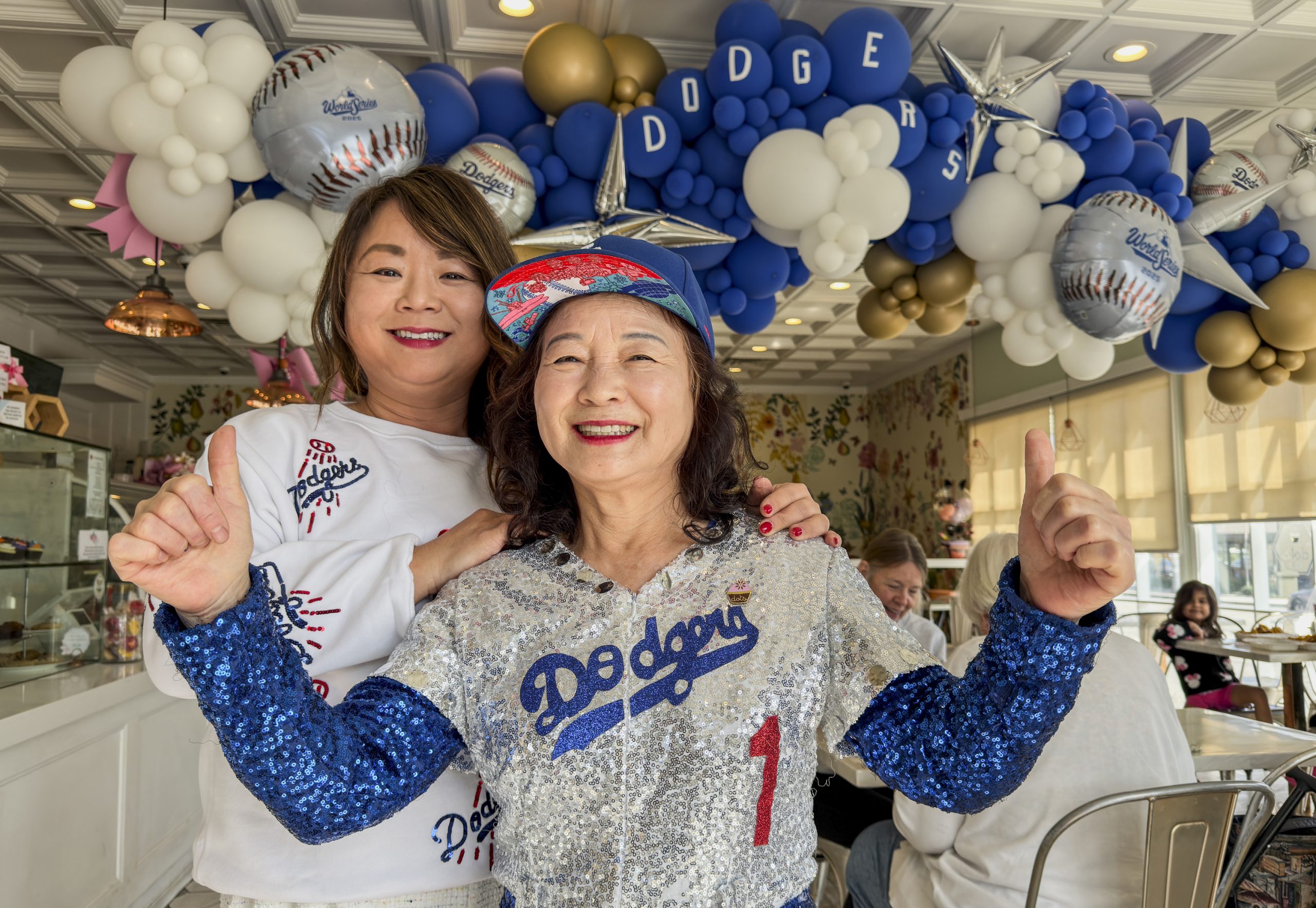 Dodgers Mom Pasadena bakery owner Aeja Kwon and her daughter decorate Dots Cafe & Bakery with Dodgers-colored balloons for the World Series.