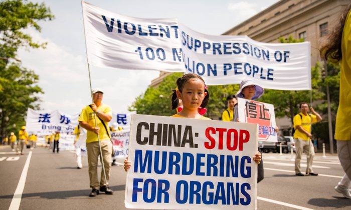 Protester raises sign reading “China: Stop Murdering for Organs” during demonstration against forced organ harvesting