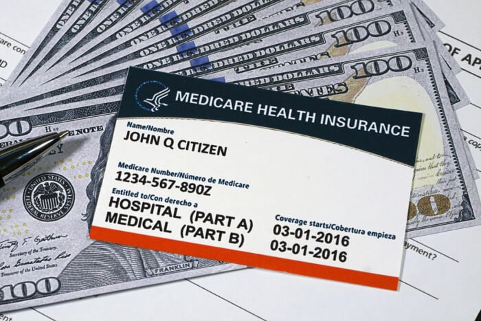 Medicare card and dollar bills illustrating rising healthcare costs under Medicare plan changes 2025