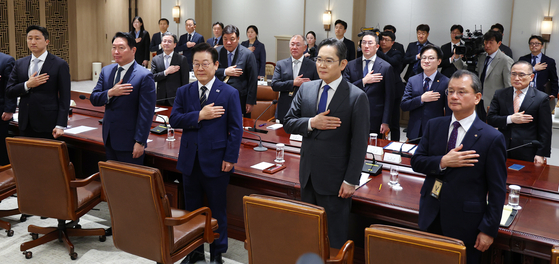From left in the front row, HD Hyundai Chairman Chung Ki-sun, SK Group Chairman Chey Tae-won, President Lee Jae Myung, Samsung Electronics Executive Chairman Lee Jae-yong, Hanwha Group Vice Chairman Yeo Seung-joo; From left in the second row, Presidential policy chief Kim Yong-beom, Celltrion Chairman Seo Jung-jin, Hyundai Motor Group Executive Chair Euisun Chung, LG Group Chairman Koo Kwang-mo, Industry Minister Kim Jung-kwan and Korean National Security Adviser Wi Sung-lac salute during a meeting about recently concluded tariff negotiations with the United States at the Yongsan presidential office in central Seoul on Nov. 16. [JOINT PRESS CORPS]