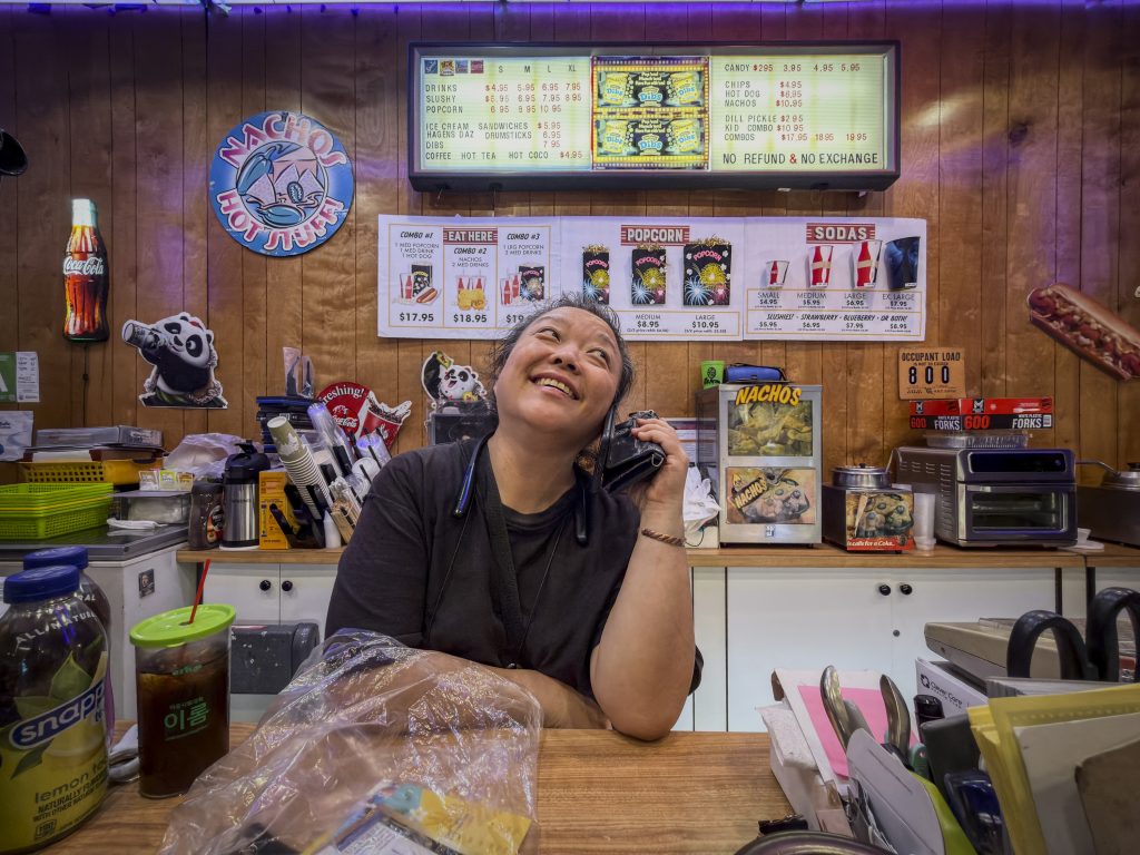 Judy Kim working at the concession stand inside Gardena Cinema while calling her father