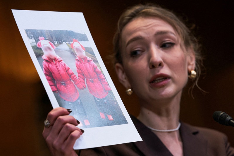 Kateryna Rashevska, a legal expert at the Regional Center for Human Rights, holds a picture of Ukrainian children as she testifies before a U.S. Senate Appropriations subcommittee hearing on the abduction of Ukrainian children by Russia on Dec. 3. [REUTERS]