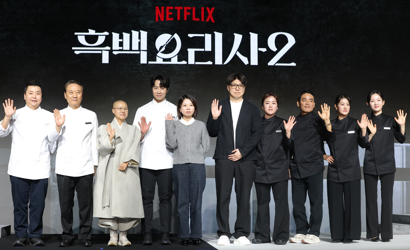 Contestants and producers of Netflix's ″Culinary Class Wars 2″ pose for photos during a news conference for the show held in Jongno District, central Seoul, on Dec. 17. From left are the White Spoon's Jung Ho-young, Hou Deok-juk, Venerable Sunjae, Son Jong-won, producers Kim Eun-ji and Kim Hak-min, the Black Spoon's Brewmaster Yun, French Papa, Witch with a Wok and Little Tiger. [YONHAP]