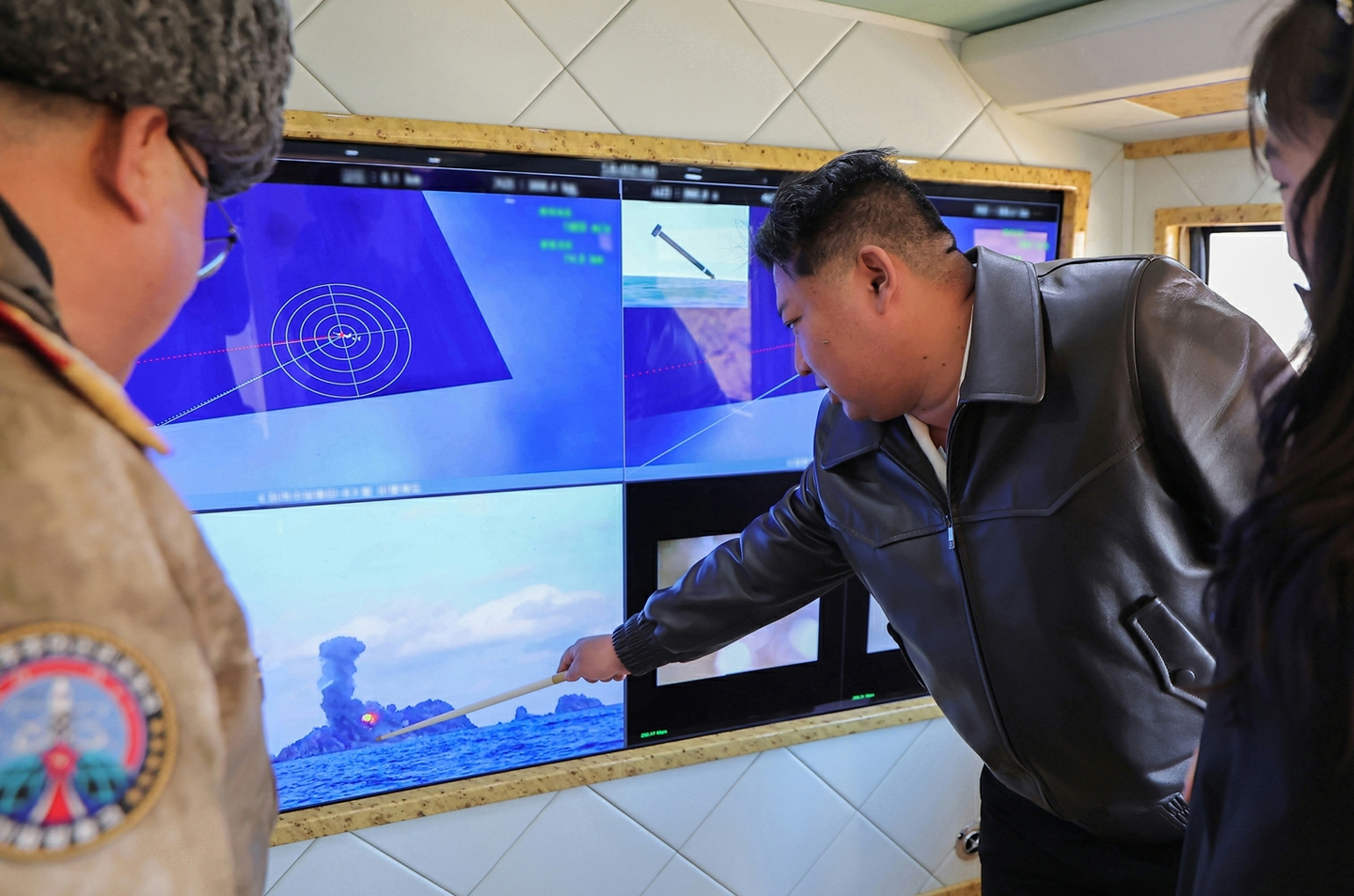 North Korean leader Kim Jong-un, center right, is seen overseeing the test-fire of an upgraded large-caliber multiple rocket launcher system (MRLS) at a facility in North Korea on Jan. 27, in this photo released by the Korean Central News Agency on Jan. 28. [KOREAN CENTRAL NEWS AGENCY]