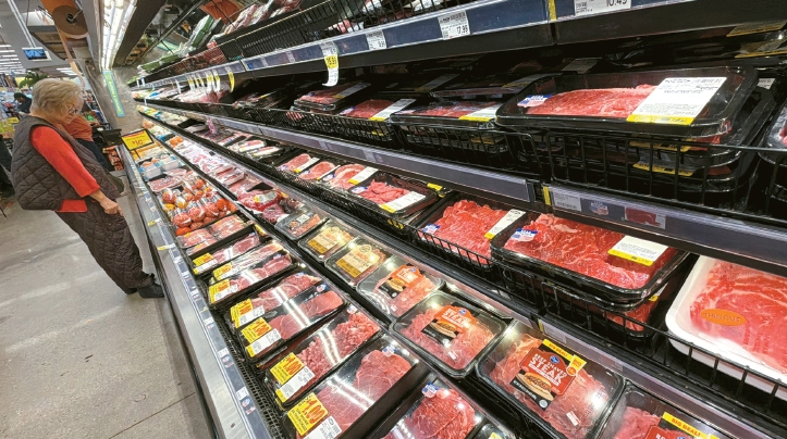 A customer checks beef prices at the Ralphs meat department amid grocery price inflation in LA.