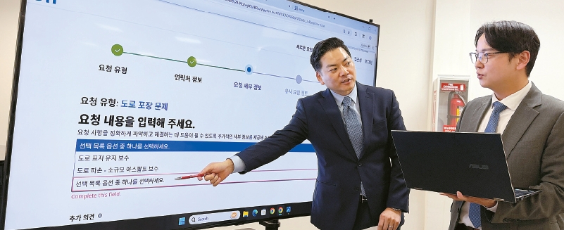 James Ahn and Steve Kang explain Koreatown pothole reporting methods at a press briefing in Los Angeles