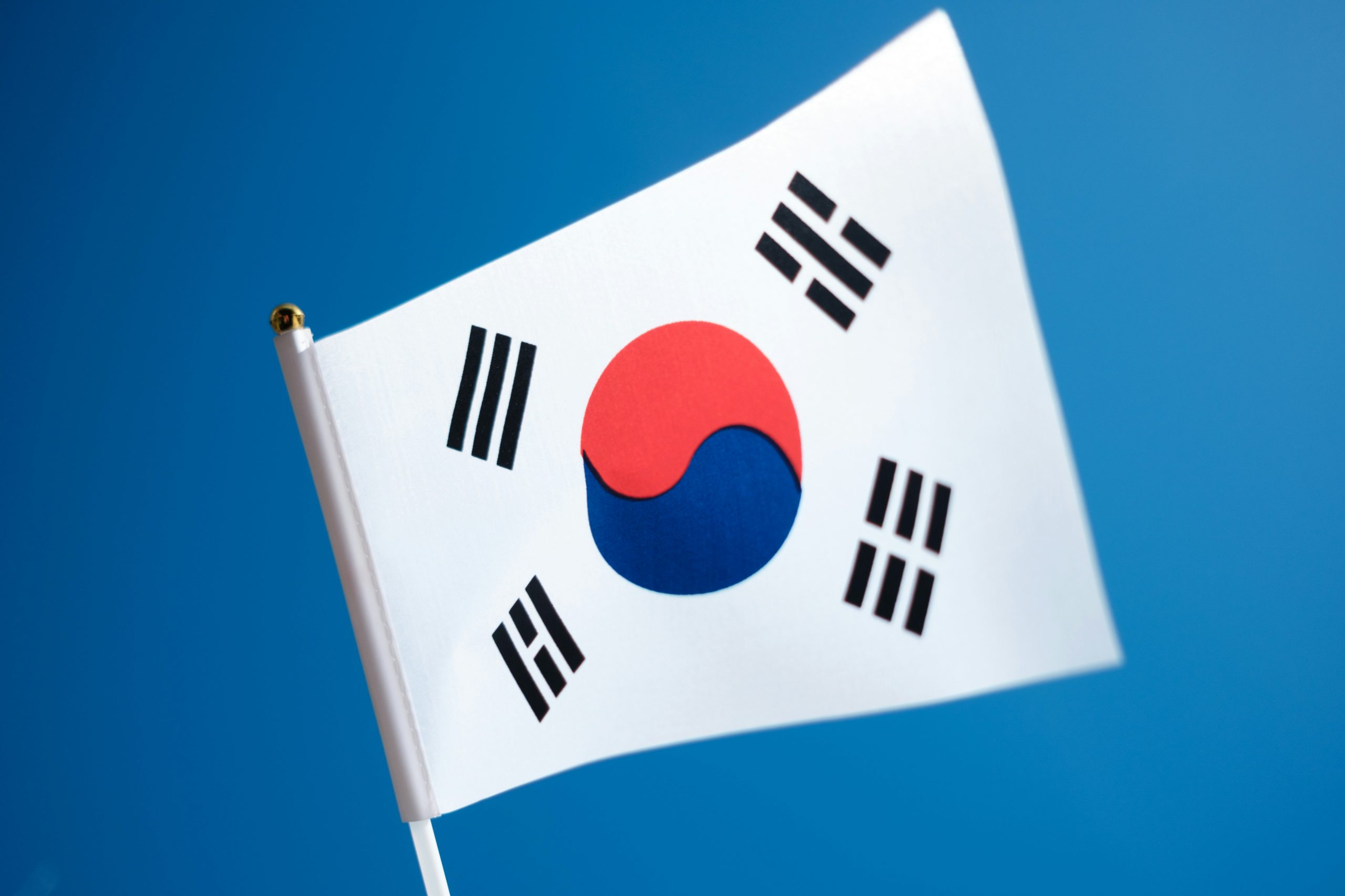 South Korean flag waving against a blue sky, symbolizing Koreans in the US and the global Korean diaspora