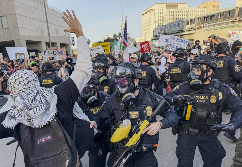 Protesters and federal agents face off at the entrance to a detention center parking lot in downtown Los Angeles on January 30. Federal agents fired tear gas and smoke canisters toward the crowd, and the standoff continued late into the night.  [Sangjin Kim, The Korea Daily]
