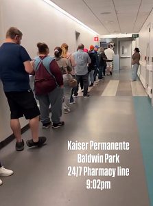 Patients stand in a long line outside the pharmacy at Kaiser Permanente Hospital in Baldwin Park. [X screenshot]