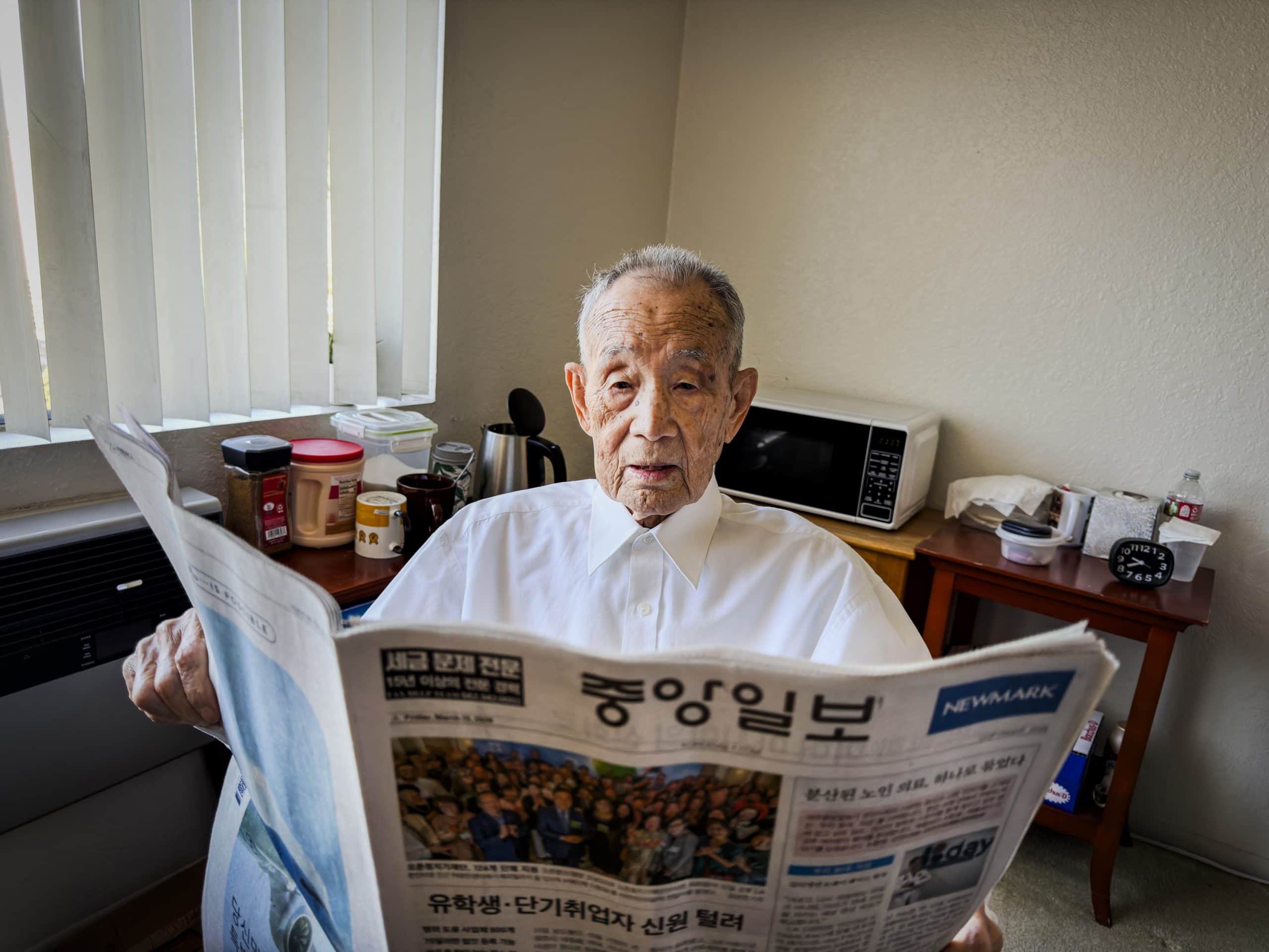 Korean War veteran newspaper reader