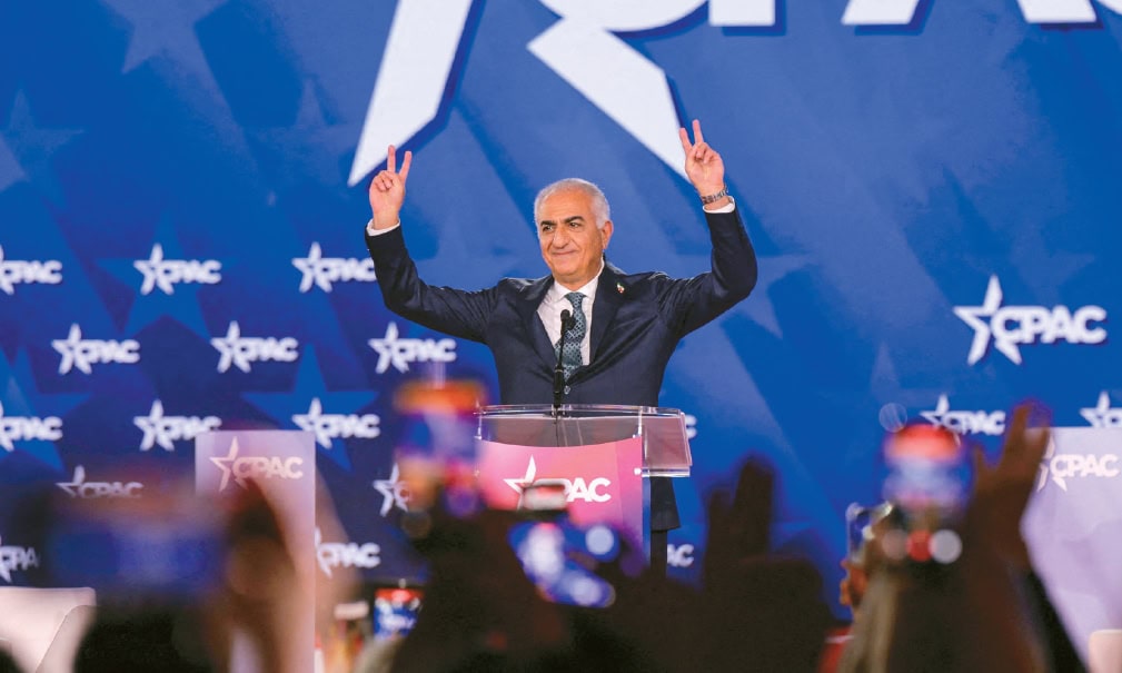 Crown Prince Reza Pahlavi flashing a V-for-victory sign at the CPAC 2026 podium during his MIGA (Make Iran Great Again) speech.