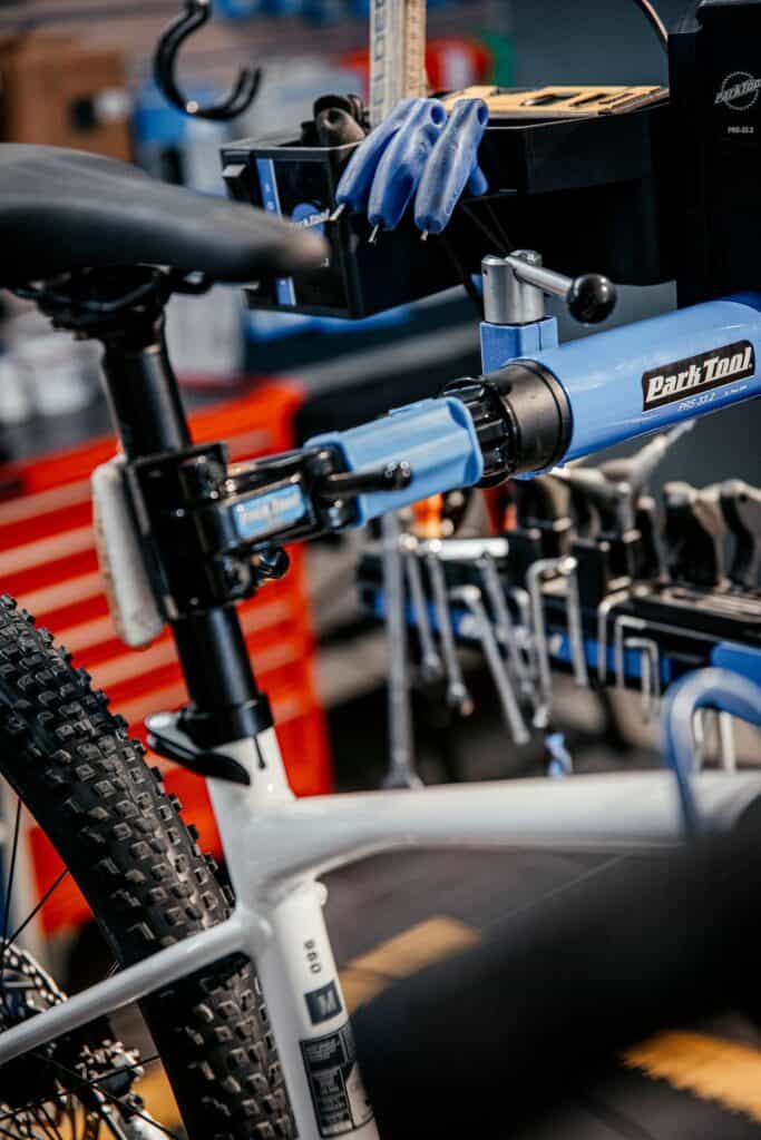 Fahrrad in Werkstatt mit Werkzeugen und Montagetisch.