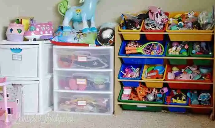toys organized into plastic bins in a playroom.