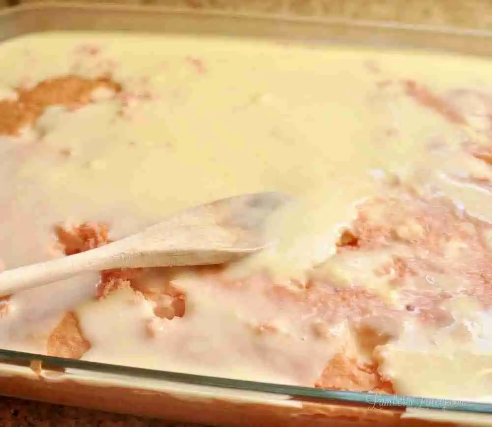 spreading pudding mix over cake.