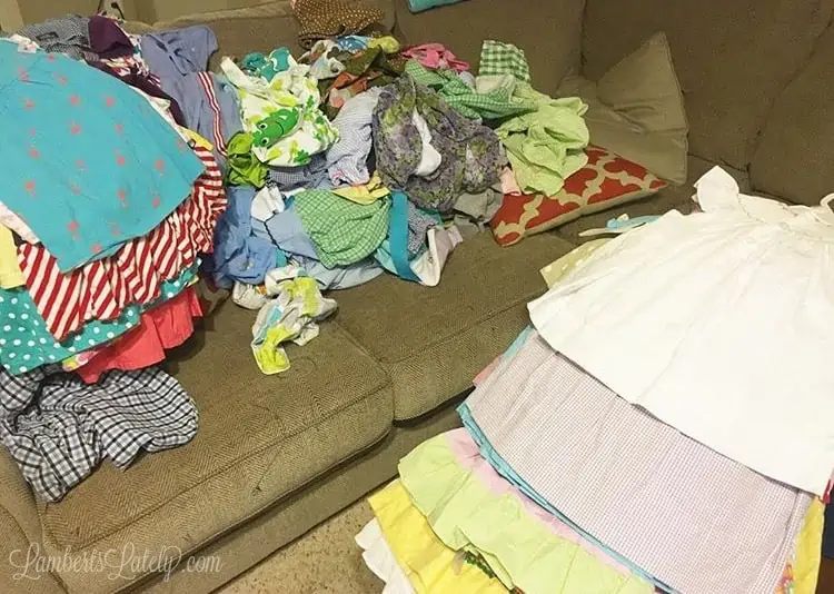 clothes stacked and piled on a couch.