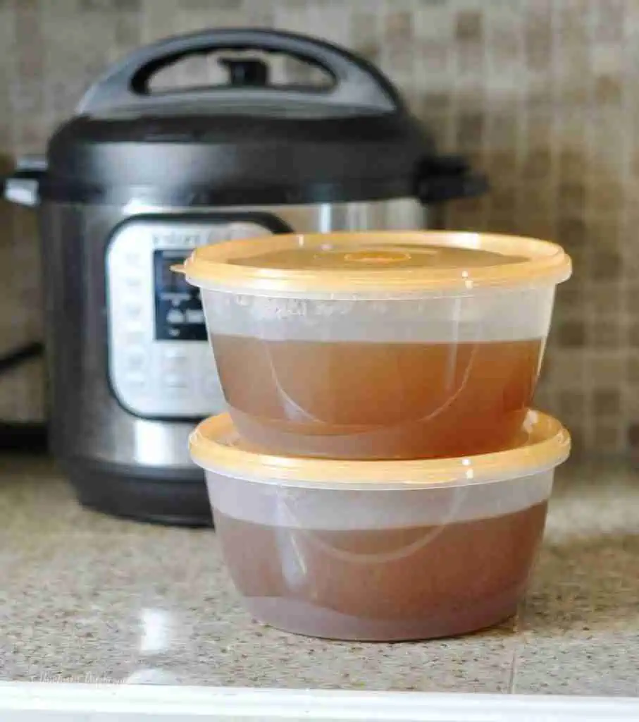 two containers of vegetable broth in front of an instant pot.