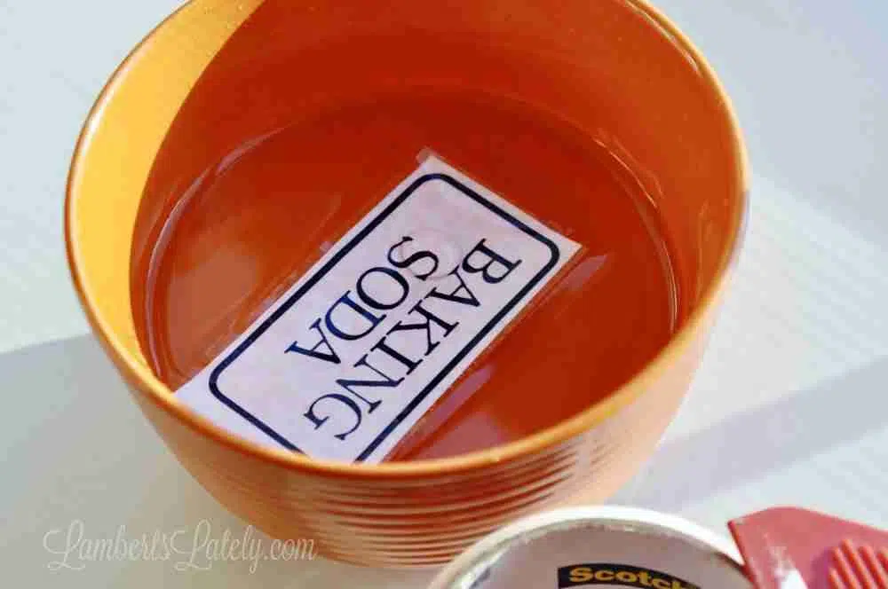 soaking baking soda label in water in a bowl.