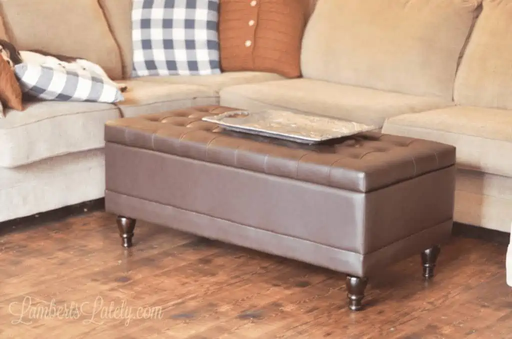 brown leather ottoman in front of a sectional couch.