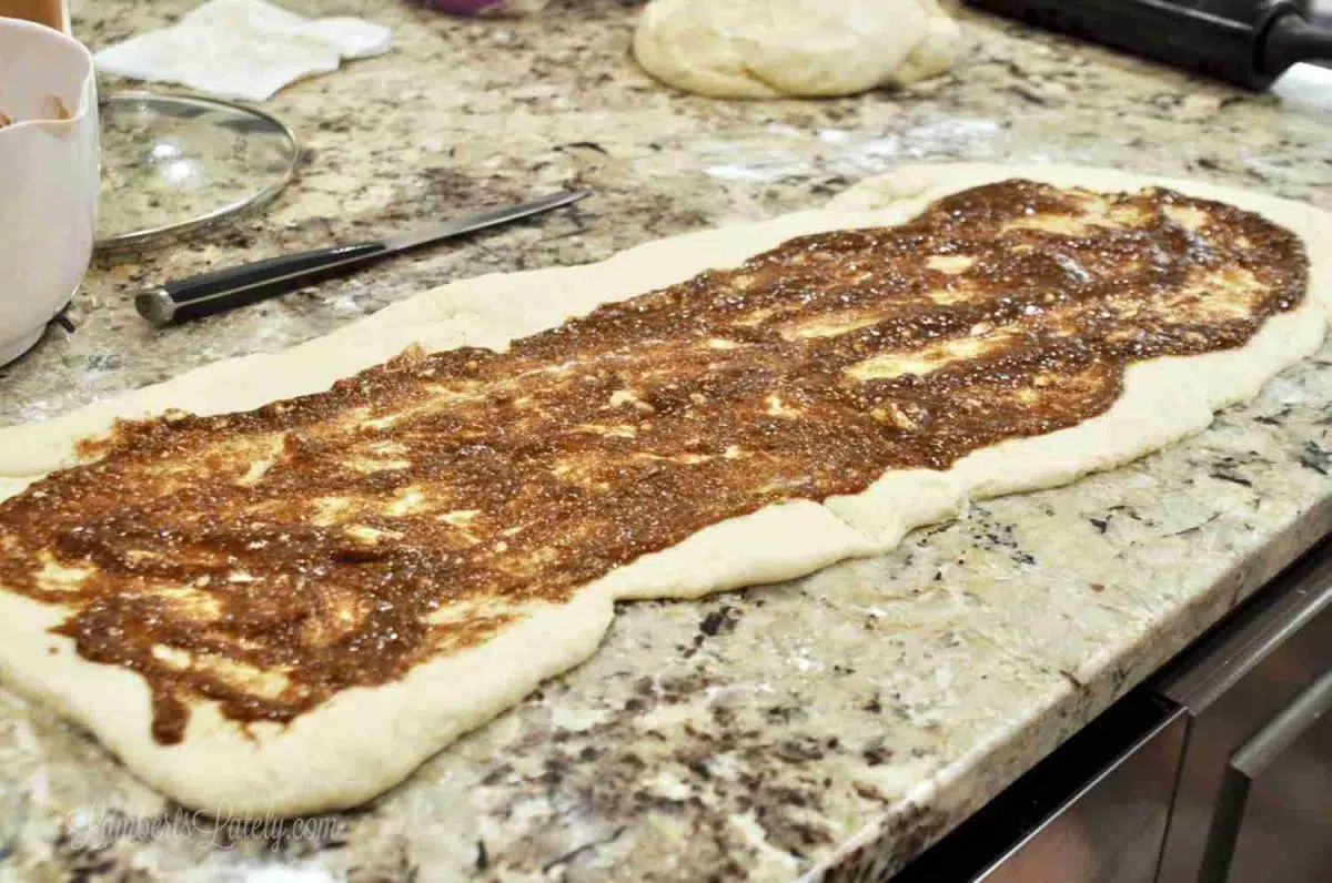 filling spread on cinnamon roll dough.
