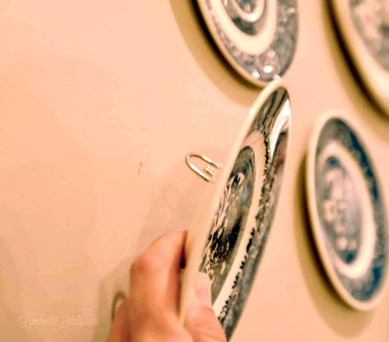 holding plate with d-ring up to the wall, pencil mark on wall.